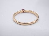 a close up of a gold ring with a ruby stone
