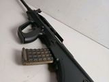 a close up of a gun with a magazine on a table