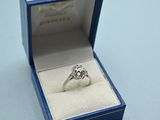 a ring in a blue box on a white surface