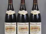 three bottles of wine sitting on top of a glass table
