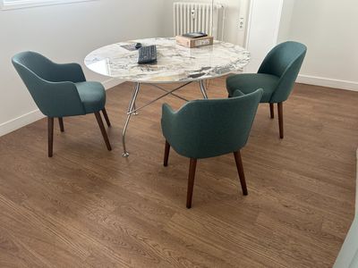 trois chaises disposées autour d'une table au plateau en marbre