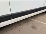 a white van with black trim parked in a parking lot