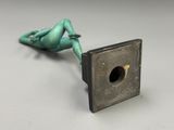 un gros plan d'une figurine posée sur un objet métallique
