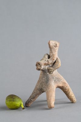 une figurine représentant un homme portant un bébé sur le dos