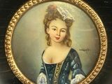 painting of a woman in a blue dress in a black and gold frame