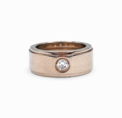 a close up view of a rose gold wedding ring with a diamond