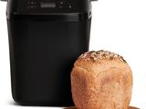 a loaf of bread sitting next to a bread dispenser on a cutting board