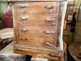 a man standing next to a wooden dresser in a room