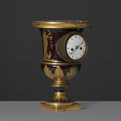 un vase doré et noir orné d'une horloge