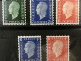 quatre timbres différents, de couleurs et de tailles variées, sur un fond noir