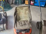 deux tondeuses à gazon qui sont rangées dans le garage