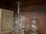 Des bouteilles et des verres sont posés sur une étagère dans une pièce.