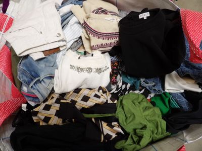 a suitcase full of clothes and clothes sitting on the floor