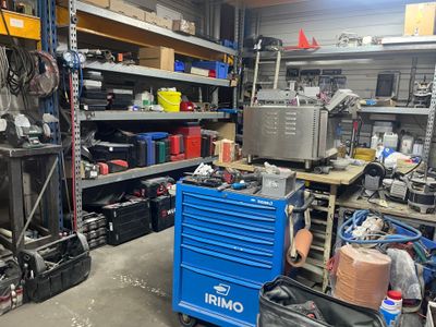 un chariot à outils bleu dans un garage rempli d'outils