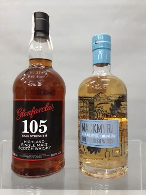 deux bouteilles de whisky posées l'une à côté de l'autre sur une étagère transparente