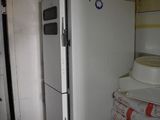several white refrigerators and freezers in a room next to each other