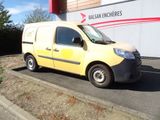 une petite camionnette jaune garée devant un immeuble