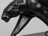 sculpture en bronze représentant une panthère posée sur un socle en marbre noir
