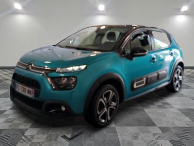 une voiture bleue Citroën garée sur un sol à damier dans un showroom