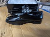 une paire de chaussures en cuir noir posée sur une table en bois
