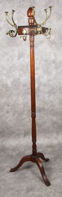 une image représentant un porte-manteau en bois surmonté de deux bougies