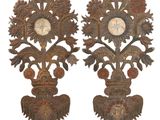 two ornate wooden sculptures with a clock on each of them