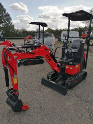 a small red excavator that is parked in the dirt