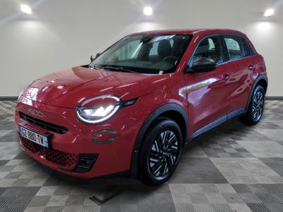 une voiture rouge garée dans un garage au sol en damier