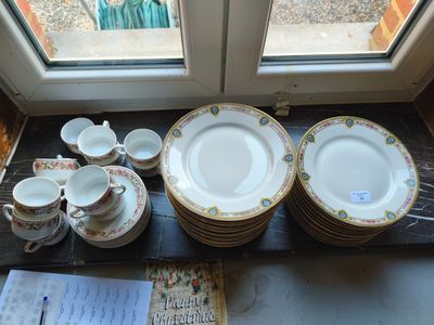 de nombreuses assiettes et tasses posées sur une table près d'une fenêtre