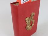 un petit livre rouge orné d'un lion doré