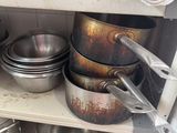 many pots and pans on the shelves in the kitchen