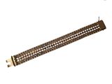 un gros plan d'un bracelet en métal sur fond blanc