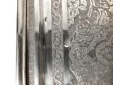 a close up of a silver plate with a pattern on it
