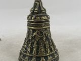 a brass bell with a black and gold design on it