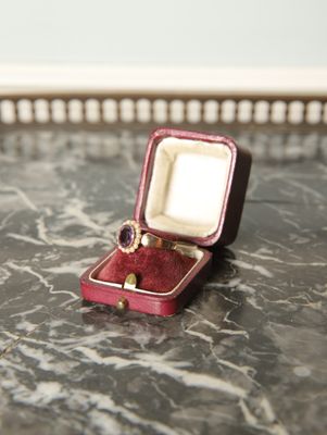 une petite boîte rouge contenant une bague, posée sur une table