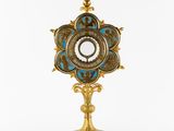 a gold and blue clock sitting on top of a metal stand