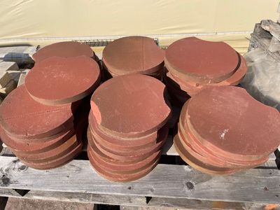 une pile d'assiettes en argile rouge posées sur une palette