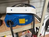 a blue machine that is sitting on a shelf in a garage