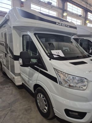 deux camping-cars blancs garés dans un grand entrepôt
