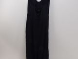 a black dress hanging on a hanger against a white wall