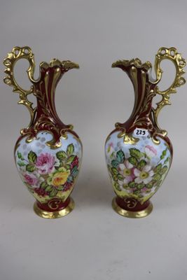 pair of vases with floral designs on them on a white surface