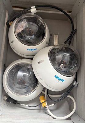 trois caméras dans une boîte, avec des fils et des câbles
