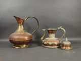 three pieces of antique copperware on a gray background