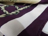 a close up of a purple and white scarf with a design on it