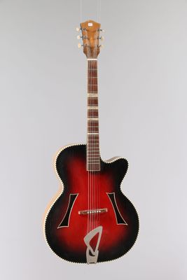 une guitare rouge et noire accrochée à un mur blanc