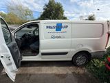 a white van that has the door open and is parked in a parking lot