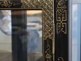 a black and gold cabinet with a mirror in it