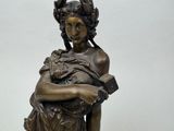 a bronze statue of a woman holding a book