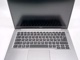 a silver laptop with a black keyboard on a white surface