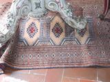 a rug on the floor next to a chair and a table